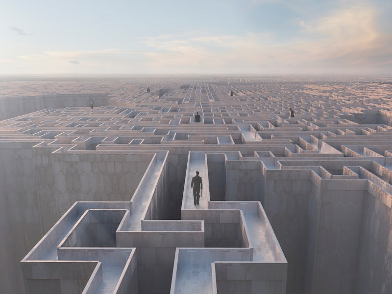 A man walking on top of a labyrinth wall