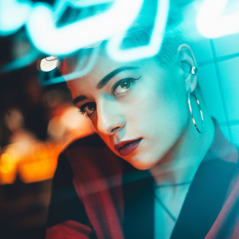 Young woman in neon lights during a bad Mercury retrograde season.