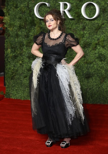 Helena on a red carpet The Crown in feathered gown