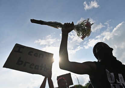 A protester in Brooklyn, New York, holding flowers above his head during a protest
