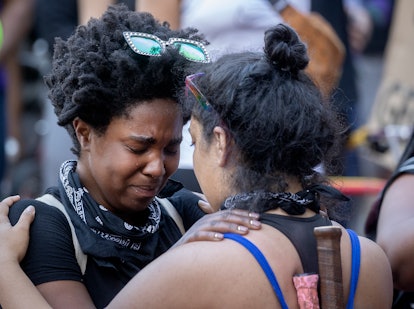 Two protesters in Minneapolis hugging and crying 