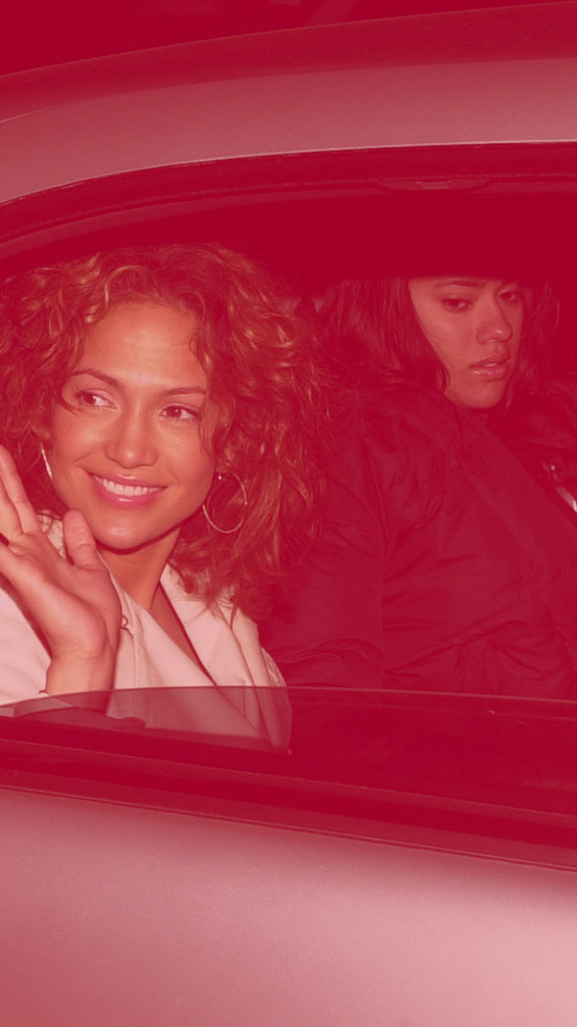 Young Jennifer Lopez in a car with minimal make-up, curly hair and hoop earrings
