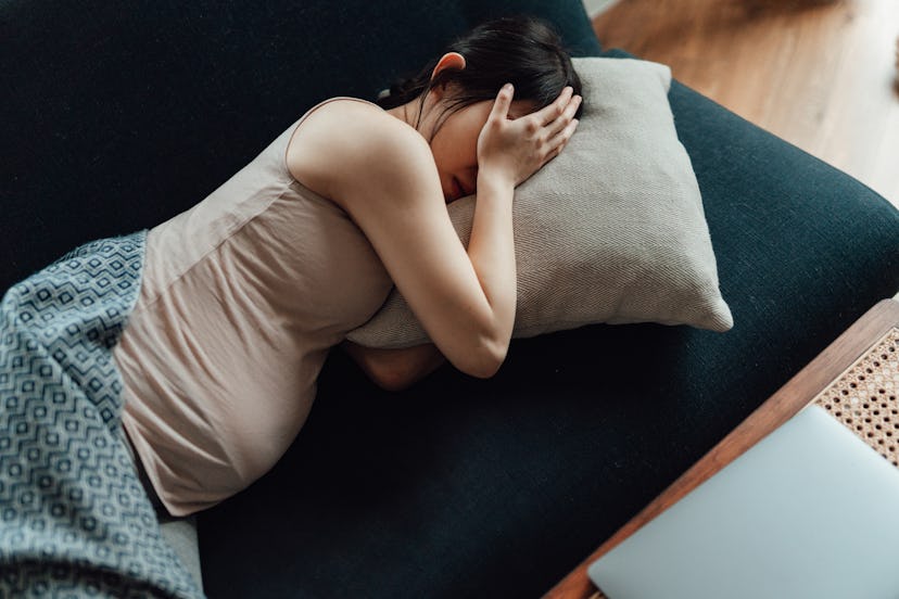 Pregnant woman with headache and hand over face