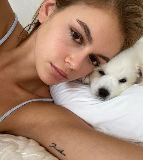 a selfie of kaia gerber and her white puppy