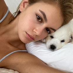 a selfie of kaia gerber and her white puppy