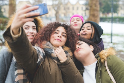 Group of 5 young women taking a selfie who may need a group chat name for their text group.