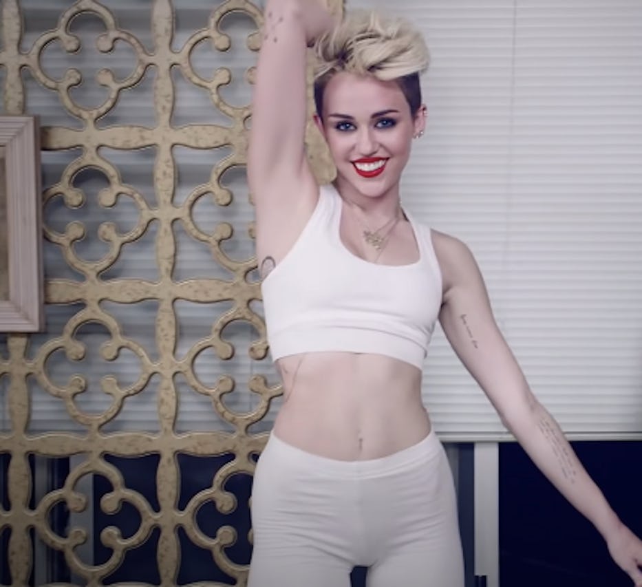 Miley Cyrus on the cover of NYLON's entertainment article in white top and shorts.