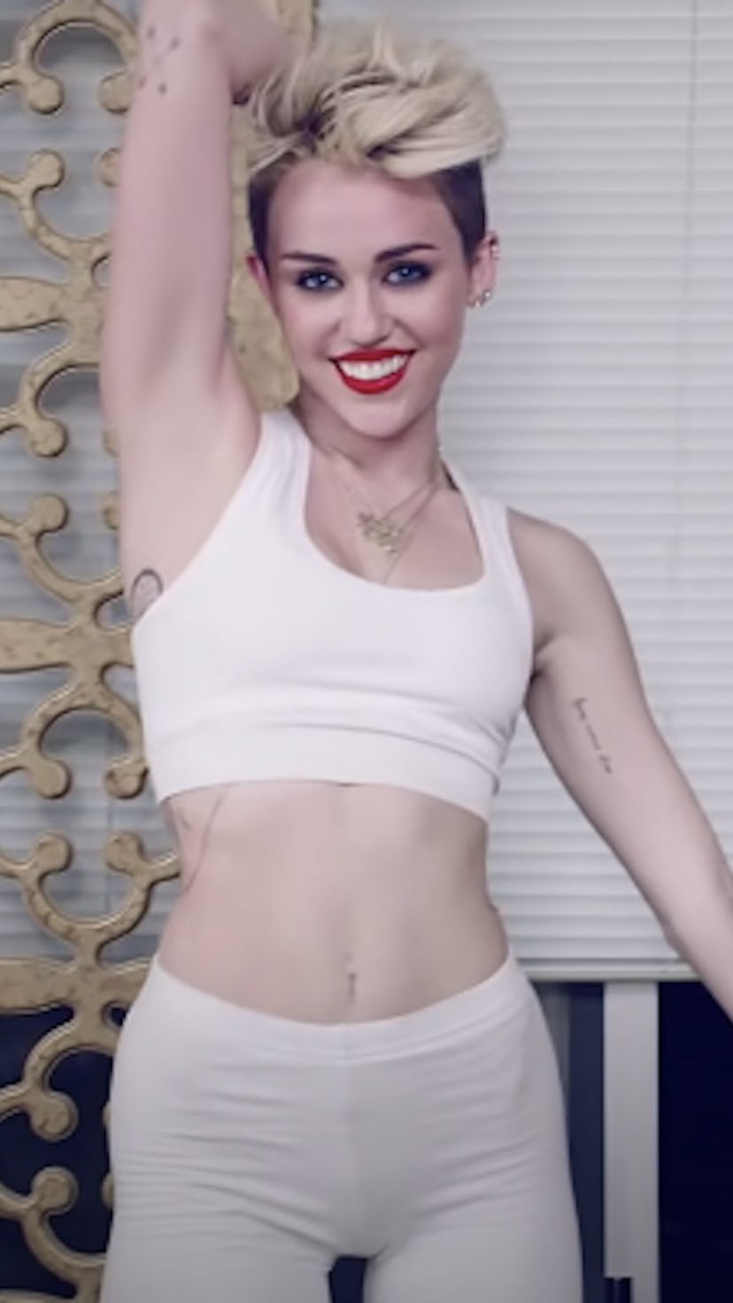 Miley Cyrus on the cover of NYLON's entertainment article in white top and shorts.