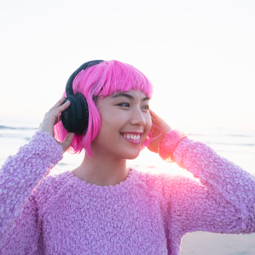 Happy young woman listening to music, having the best time the week of May 31, 2021.