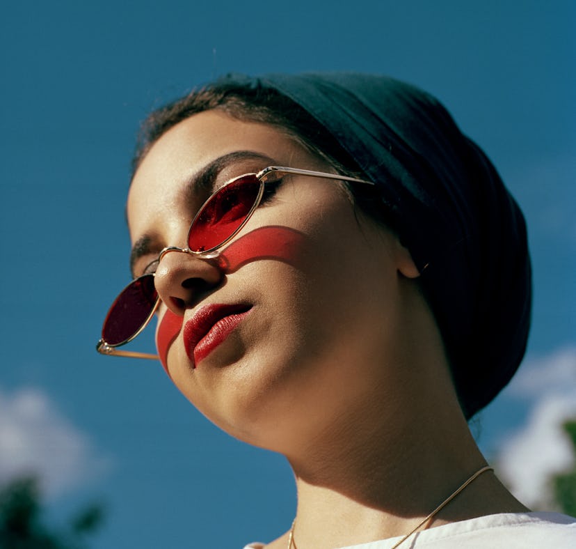 Young woman with red sunglasses during the week of May 31, 2021, waiting for her weekly horoscope.