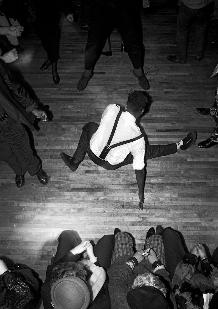 A man breakdancing with a group of people standing around him at Legends, London, 1986.