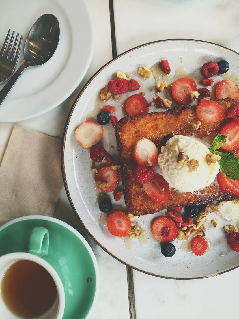 Plat with french toast topped with ice cream, berries, and granola crumbles