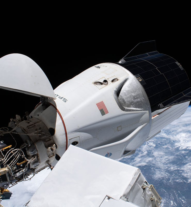 The SpaceX Crew Dragon spacecraft, with its nose cone open, is pictured docked to the Harmony module...