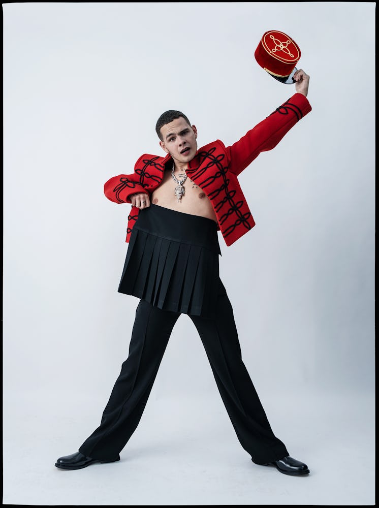 Slowthai wears a Louis Vuitton Men’s jacket, skirt, and pants; vintage hat from the Costume Studio, ...