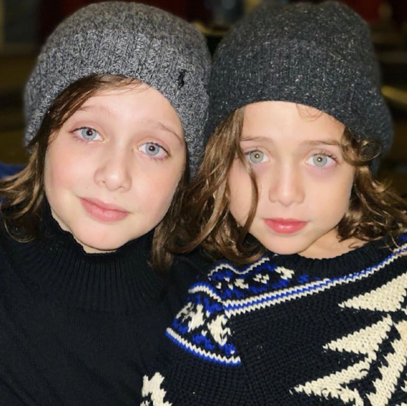 two kids with winter hats on, looking chic 