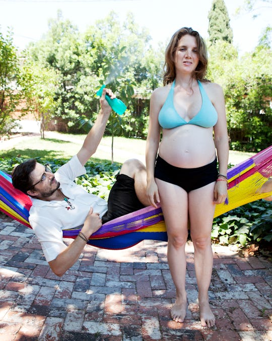 man fanning and spraying his pregnant partner during the summer