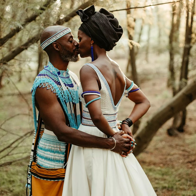 Groom and bride kissing, bride is wearing colorful beaded Xhosa jewelry. 