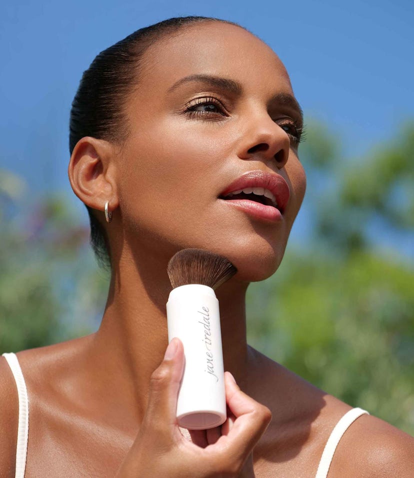 A woman applying Jane Iredale's SPF powder.