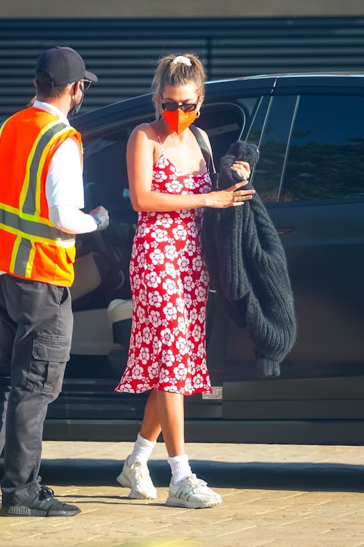 Hailey Bieber out for dinner in Nobu Malibu on May 5, wearing red Hawaiian print slip dress from Hol...