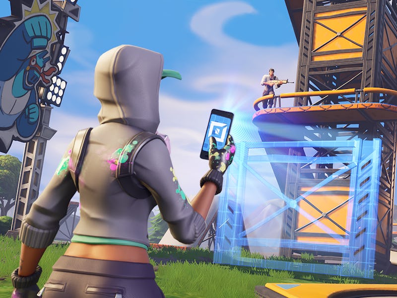 A character from Fortnite using a smartphone and taking a picture with a defense tower in the backgr...