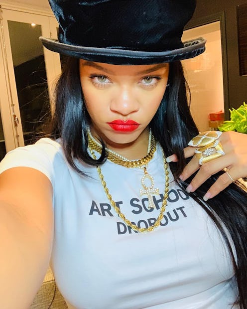 selfie of rihanna wearing red lipstick, gold jewels, and a top hat