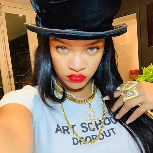 selfie of rihanna wearing red lipstick, gold jewels, and a top hat 