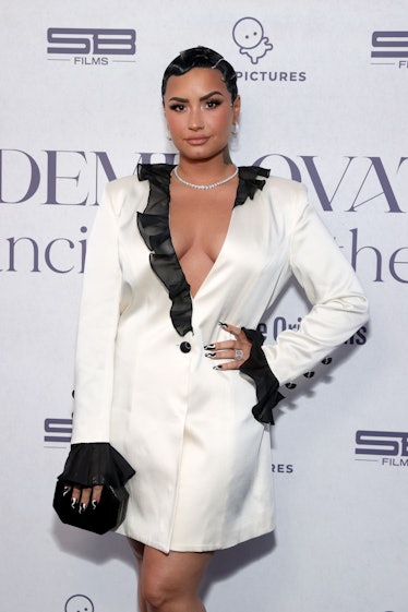Demi Lovato posing in an oversized white blazer rocking a Betty Boop Pixie cut