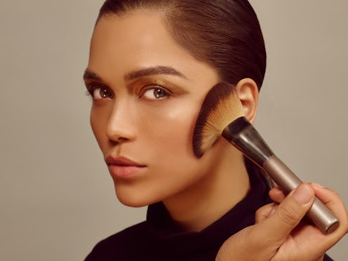 Woman wearing makeup and using makeup brush