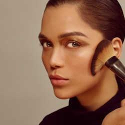 Woman wearing makeup and using makeup brush