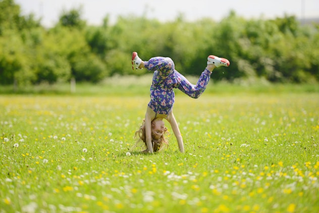 child cartwheeling in field