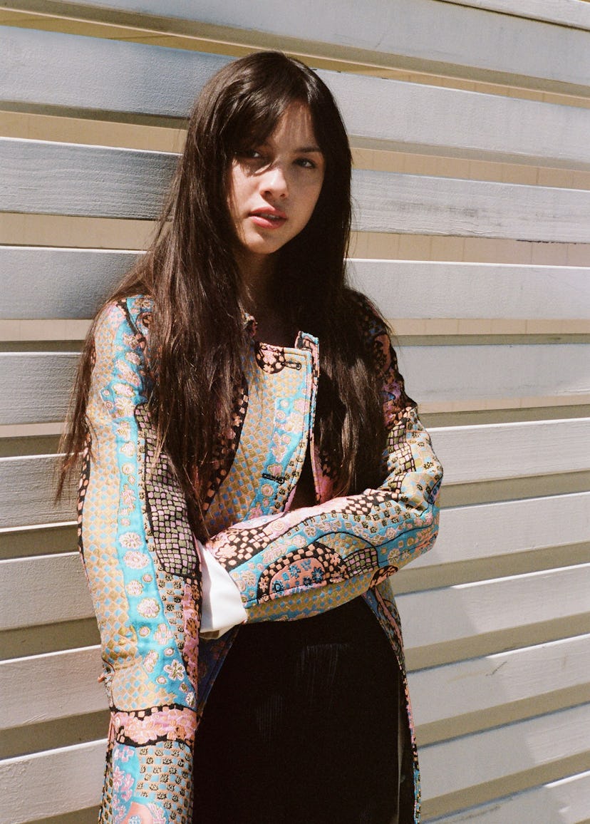 Olivia Rodrigo in front of planks.