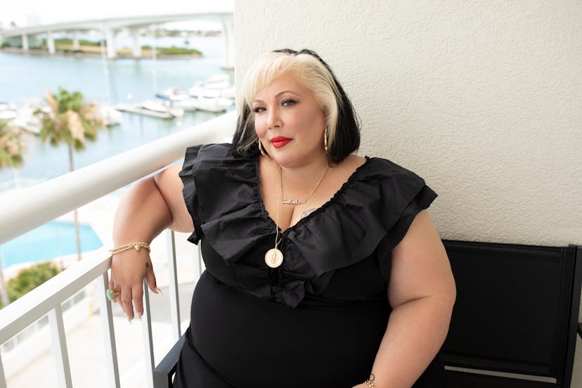 Jae Rae sitting on a balcony in a black dress