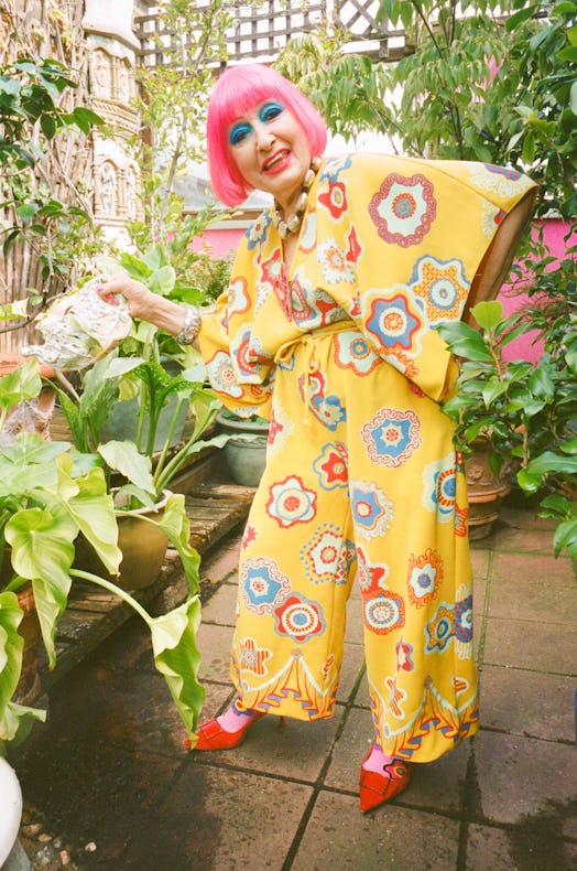 Dame Zandra Rhodes in a floral yellow romper in her London penthouse