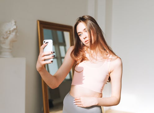 A woman takes a selfie, wondering if her sudden breast growth in her 20s is a cause for concern.