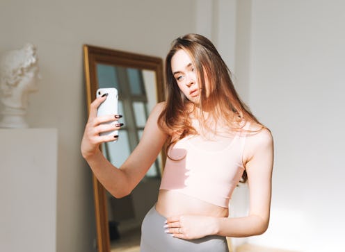 A woman takes a selfie, wondering if her sudden breast growth in her 20s is a cause for concern.