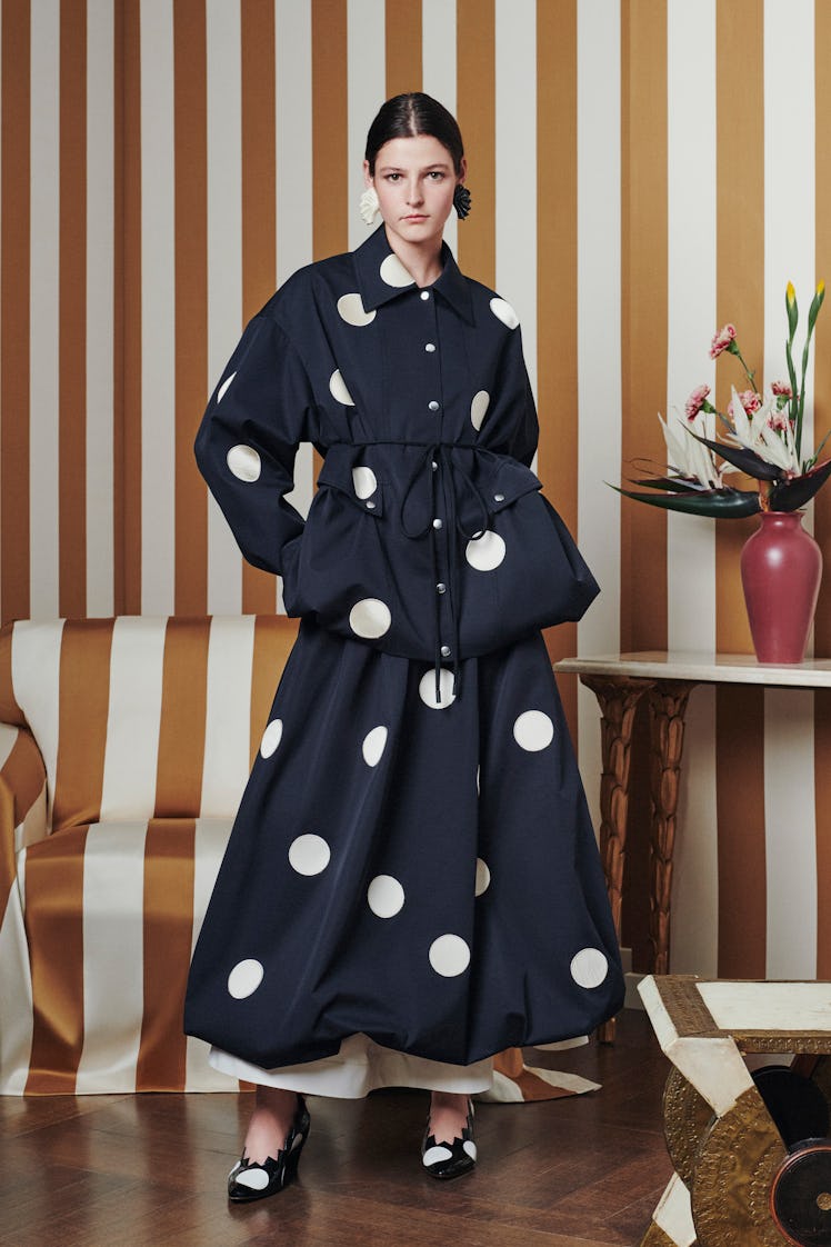 A model posing while wearing a Tory Burch black gown with white dots
