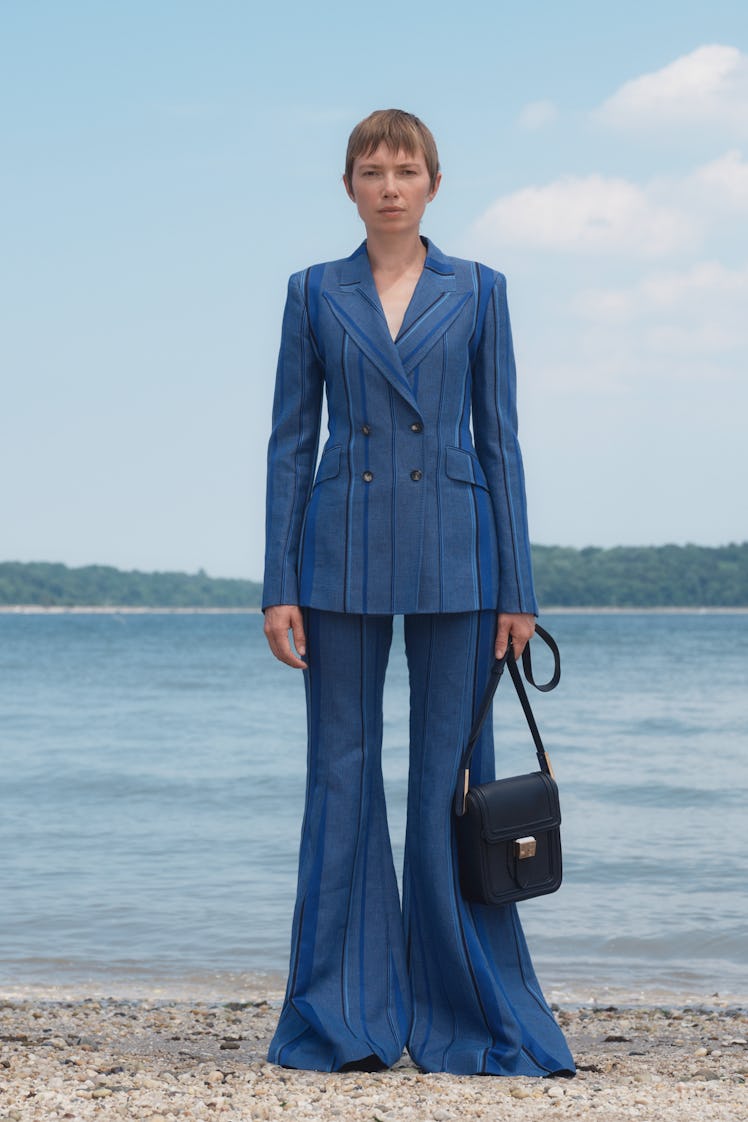 A female model posing in a Gabriela Hearst blue blazer and baggy pants combination