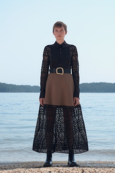 A model posing while wearing a black Gabriela Hearst dress