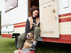 Young woman in a motor van with her dog, posing for a fun Instagram.