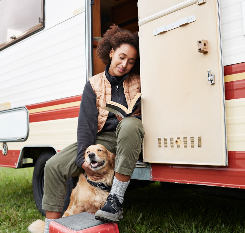 Young woman in a motor van with her dog, posing for a fun Instagram.