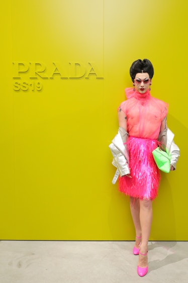 Violet Chachki in pin-up style in a pink see-through top and pink shiny fringed skirt at the Prada s...