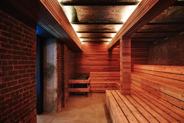 The sauna at the Bathhouse with a brick wall and wooden benches