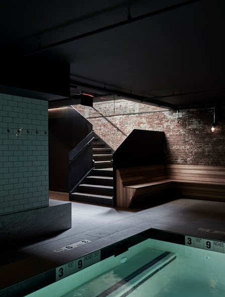  A Bathhouse in Brooklyn, an oasis-like spa, a dark room with stairs leading up, and a pool