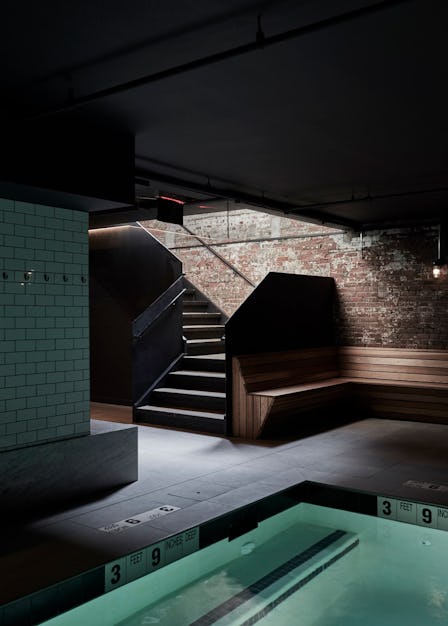 A Bathhouse in Brooklyn, an oasis-like spa, a dark room with stairs leading up, and a pool