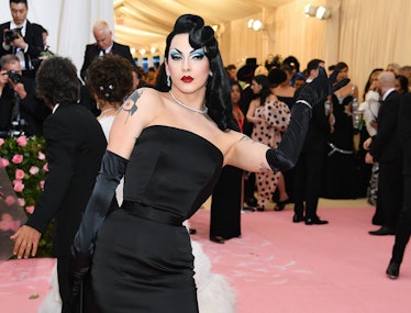 Violet Chachki in a black dress and black gloves in pin-up style at a red carpet event