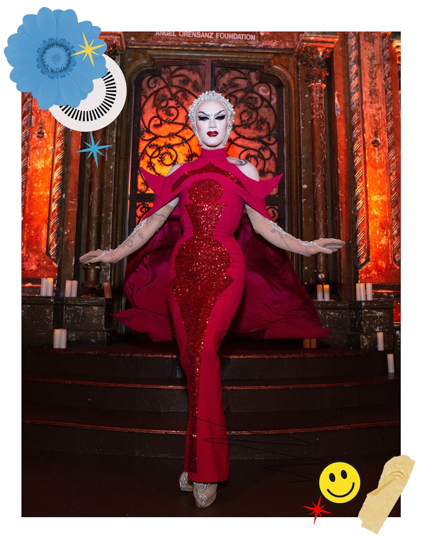 Sasha Velour wearing a red gown with a cape and a white wig