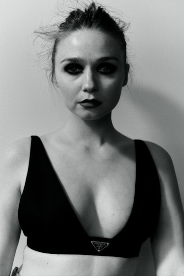 A portrait of Jessica Barden with smoky-eye makeup in a bralette in black-and-white