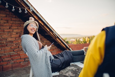 Millennial woman sitting on a rooftop, who's mentally her own age, per her zodiac sign.