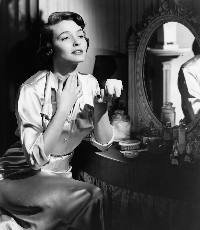 A woman applying a neck cream.