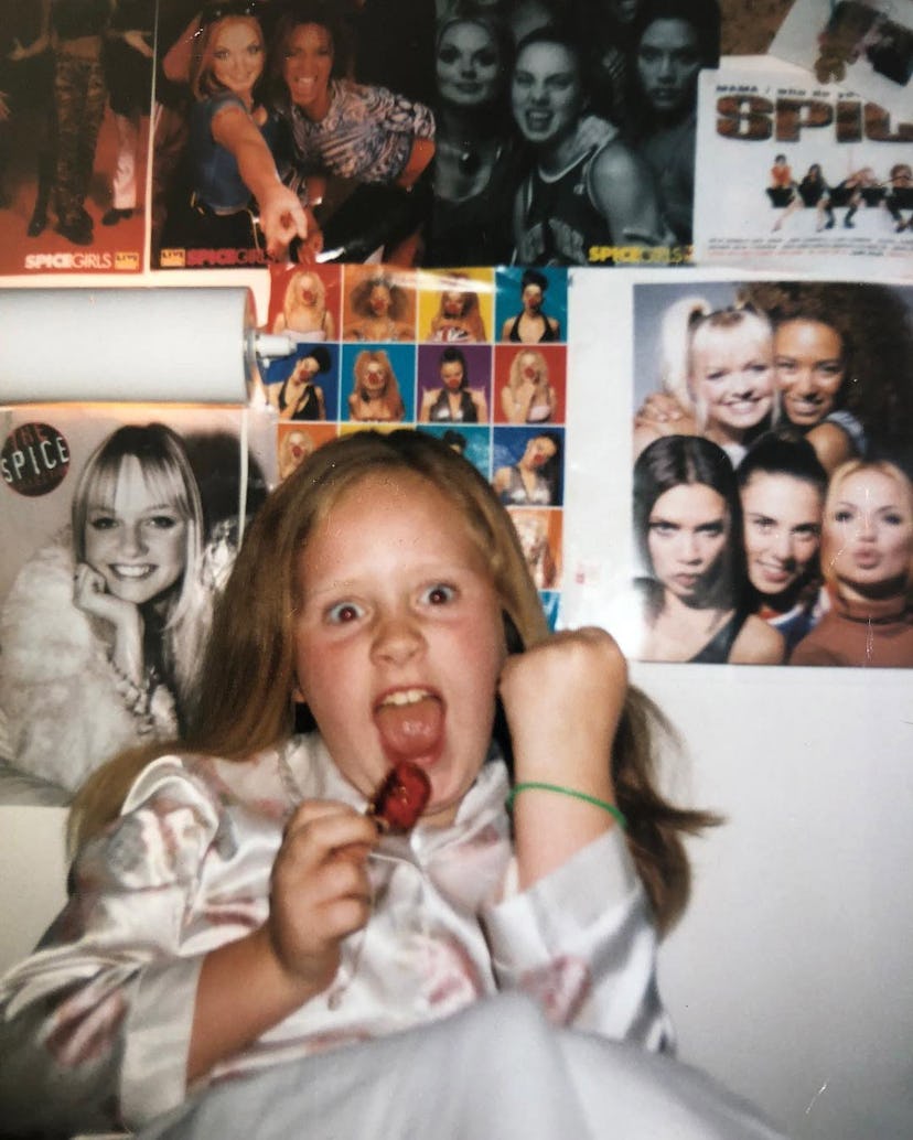 Adele as a young child, posing in front of her Spice Girls posters